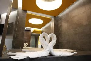łazienka z dwoma łabędzie wykonanymi z ręczników w obiekcie Hotel Luve w mieście San Antonio de Banageber