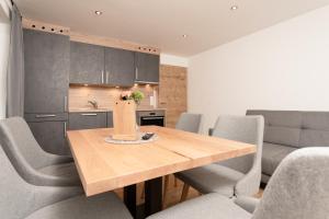 cocina y comedor con mesa de madera y sillas en Bergnest Oetztal - Appartements, en Umhausen
