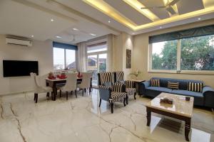 a living room with a couch and a dining room at Antalya Villa - 5BHK with Private Pool, Baga in Baga