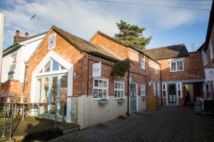 an old brick building with a white door at Apartment Two at the Courtyard, Number 11 in Audlem