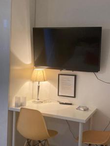 a desk with a lamp and a monitor on a wall at Auszeit am Haffufer in Wilhelmshof