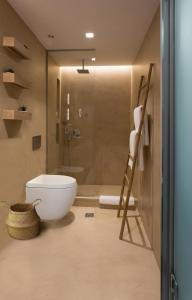 a bathroom with a toilet and a glass shower at Artree Suites in Heraklio