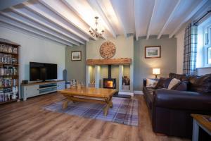 uma sala de estar com um sofá, uma mesa e uma lareira em Host & Stay - Millfield Cottage em Chop Gate