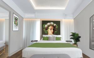 ein Schlafzimmer mit einem großen Bett mit einem Bild einer Frau in der Unterkunft Artree Suites in Iraklio
