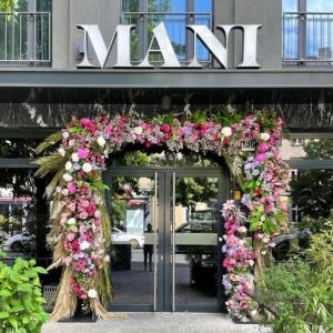 an entrance to a building with an arch of flowers at Hotel MANI by AMANO in Berlin
