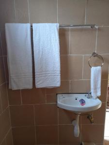 łazienka z umywalką i ręcznikami na ścianie w obiekcie THE PLANTAINS PLACE w mieście Karatina