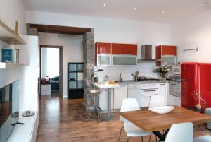 La cuisine est équipée de placards blancs et d'un réfrigérateur rouge. dans l'établissement Appartamento incantevole a Trieste, à Trieste