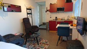 eine Küche mit roten Schränken sowie einem Tisch und Stühlen in der Unterkunft Goody in Zandvoort