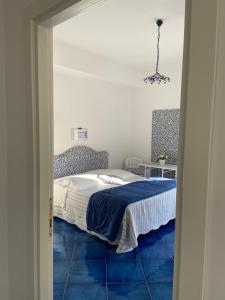 a bedroom with a bed with a blue floor at Casa Blu Cobalto in Maiori