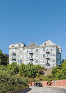 un grande edificio bianco con macchine parcheggiate di fronte di Elegant Bergen City Center Apartment - Ideal for business or leisure travelers a Bergen