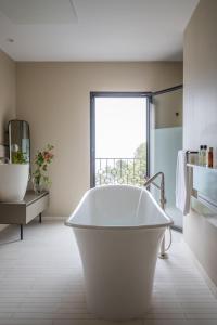 La salle de bains est pourvue d'une baignoire blanche et d'une fenêtre. dans l'établissement Misincu, à Cagnano