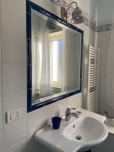 a white bathroom with a sink and a mirror at Casa Blu Cobalto in Maiori