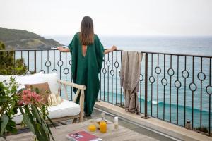 a woman standing on a balcony looking out at the ocean at Misincu in Cagnano