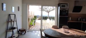 a kitchen with a table and a large sliding glass door at Une escapade en Luberon in Bonnieux