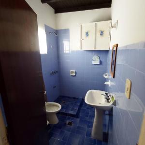 a blue and white bathroom with a toilet and a sink at Exte Maitena in Balneario Claromecó