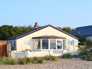 a house with a large window and an awning at Thalassa in Pagham