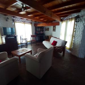 ein Wohnzimmer mit Sofas, einem Tisch und Fenstern in der Unterkunft Exte Maitena in Balneario Claromecó