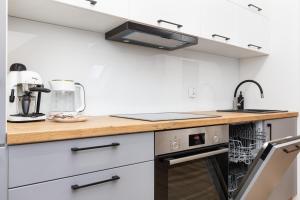 a kitchen with white cabinets and a sink at Apartamenty Morskie Oko by Renters in Międzyzdroje