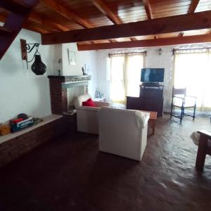 ein Wohnzimmer mit einer weißen Couch und einem Kamin in der Unterkunft Exte Maitena in Balneario Claromecó
