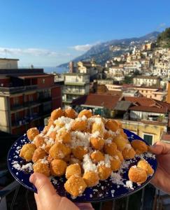 a person holding a plate of food on top of a city at Casa Blu Cobalto in Maiori