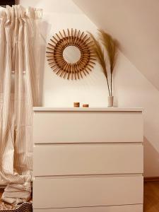 a white dresser with a mirror on the wall at Deich Winde 9.2 in Dorum Neufeld