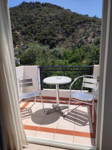 a table and two chairs on a balcony with a view at MIRSINI HOTEL in Plomari