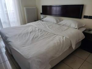 a large white bed with white sheets and pillows at Hotel Cortina in Mestre