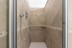 une douche avec un tuyau dans une salle de bain dans l'établissement Villa Eleonora Residence App to 4, à Capoterra 9 autres photos