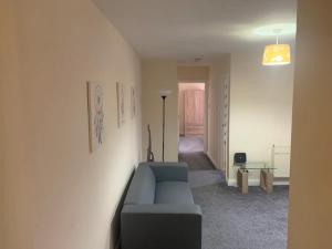 a living room with a blue couch and a lamp at A Lovely Double Bedroom + Private Bathroom in Kettering