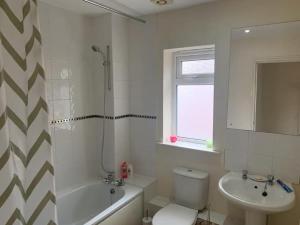 a bathroom with a toilet and a sink and a shower at A Lovely Double Bedroom + Private Bathroom in Kettering