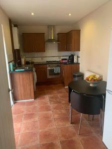 a kitchen with a table with a bowl of fruit on it at A Lovely Double Bedroom + Private Bathroom in Kettering