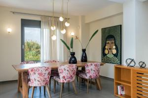 uma sala de jantar com uma mesa de madeira e cadeiras em Villa Merlin em Galatás