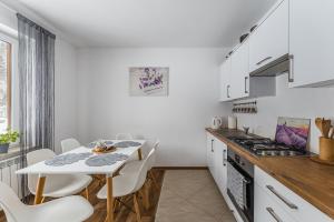 a white kitchen with a table and chairs in a room at Domki Pod Jarmutą in Szczawnica