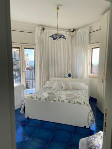 a bedroom with a white bed and a blue floor at Casa Blu Cobalto in Maiori