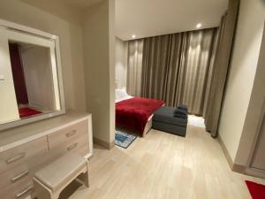 Schlafzimmer mit einem Bett, einer Kommode und einem Spiegel in der Unterkunft Marlyn Paradys in Salalah