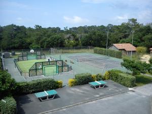 einen Blick über einen Tennisplatz mit zwei Tennisplätzen in der Unterkunft Village Vacances La Forêt des Landes in Tarnos