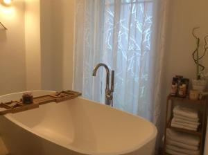 a bath tub in a bathroom with a shower curtain at Auszeit am Haffufer in Wilhelmshof +19 photos