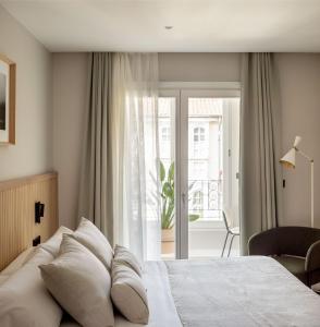 a bedroom with a bed and a sliding glass door at NIREA HOTEL in Vitoria-Gasteiz