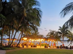 新山的住宿－COUNTRY GARDEN@J Agape Homestay ~ STUDIO COMFORT，海滩上设有桌子和遮阳伞,棕榈树