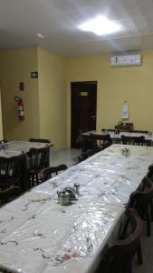 a room with rows of tables and chairs with white table cloth at WJ Hotel in Afogados da Ingàzeira