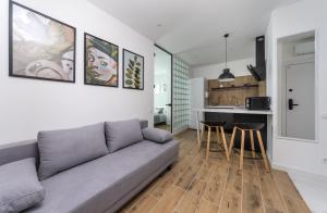 a living room with a couch and a kitchen at MYFREEDOM Апартаменти, Теремки, ВДНГ in Kyiv