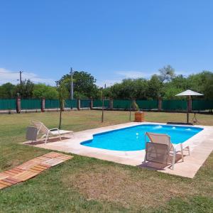 einen Pool mit 2 Liegestühlen und einem Sonnenschirm in der Unterkunft Finca La Candelaria in Santiago del Estero