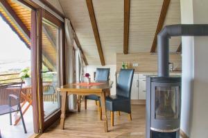 a dining room with a table and a fireplace at Ferienwohnungen Talblick 3 in Fladungen