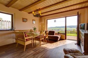 uma sala de estar com uma mesa e cadeiras e uma televisão em Ferienwohnungen Talblick 3 em Fladungen