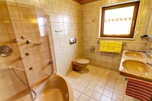 a bathroom with a tub and a sink and a toilet at Ferienwohnungen Talblick 3 in Fladungen +19 photos