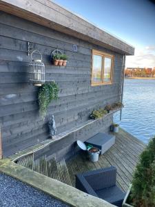 a wooden house with a bench on the side of the water at Bed & Breakfast ‘t Westergouwertje in Gouda