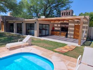 un patio trasero con piscina y una casa en Finca La Candelaria en Santiago del Estero