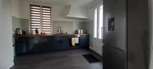 kuchnia ze zlewem i lodówką w obiekcie Spacious 3-Bed House in Chateau Garnier w mieście Château-Garnier