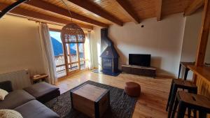 a living room with a couch and a wood stove at Boí Taüll CALMA DÚPLEX in Taüll