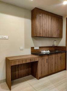uma cozinha com armários de madeira e um lavatório em RR Mount Elite Suites em Chennai